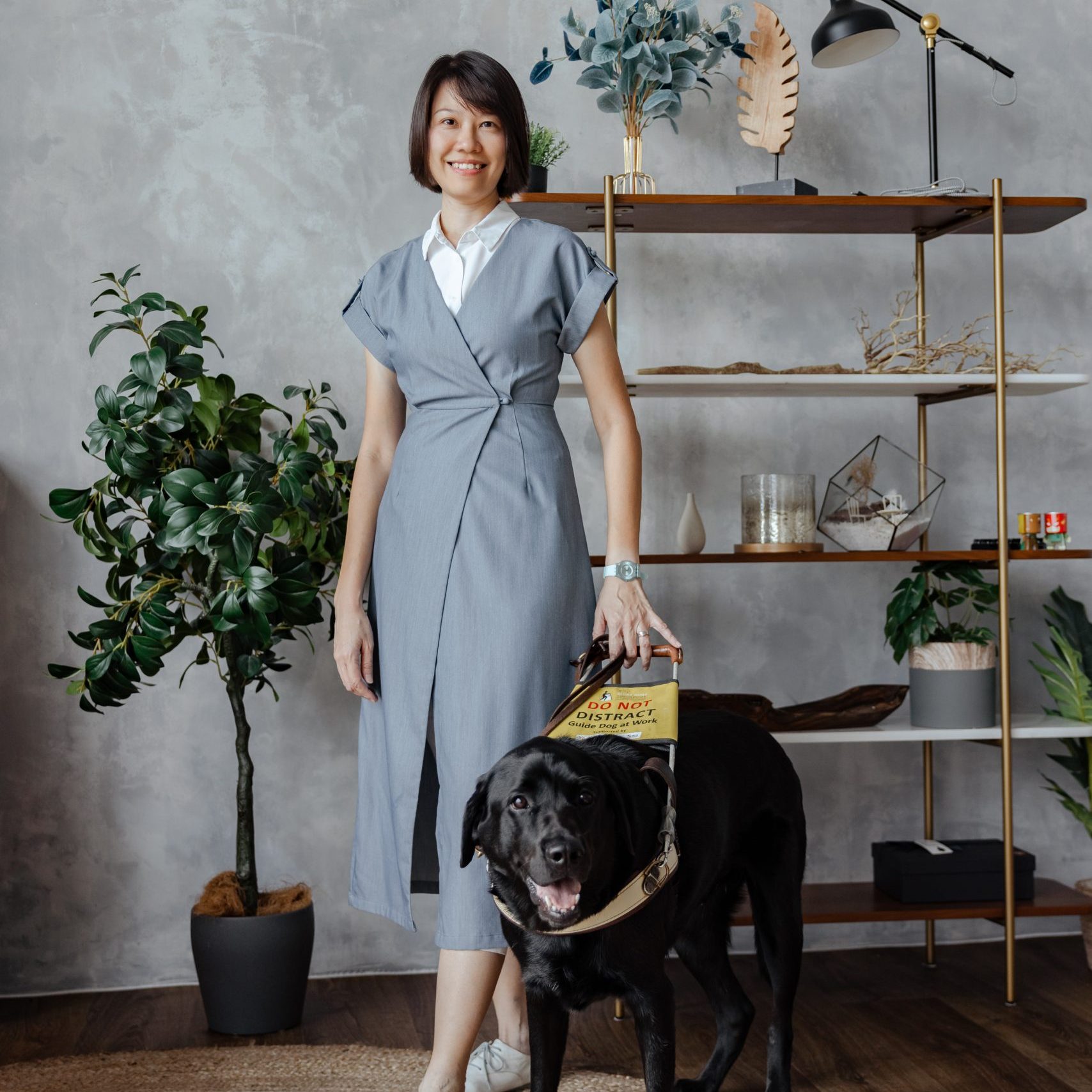 Christina Teng, Guide Dog Mobility Instructor, posing with a black guide dog.