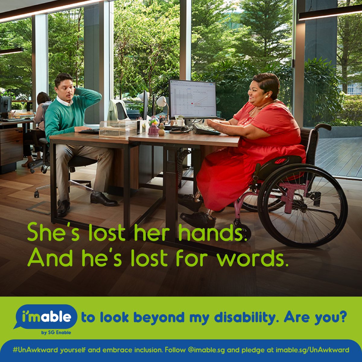 A woman sits in her wheelchair, using a laptop, while her colleague across from her wears a puzzled expression A woman sits in her wheelchair, using a laptop, while her colleague across from her wears a puzzled expression. It is accompanied by the text "She's lost her hands. And he's lost for words".