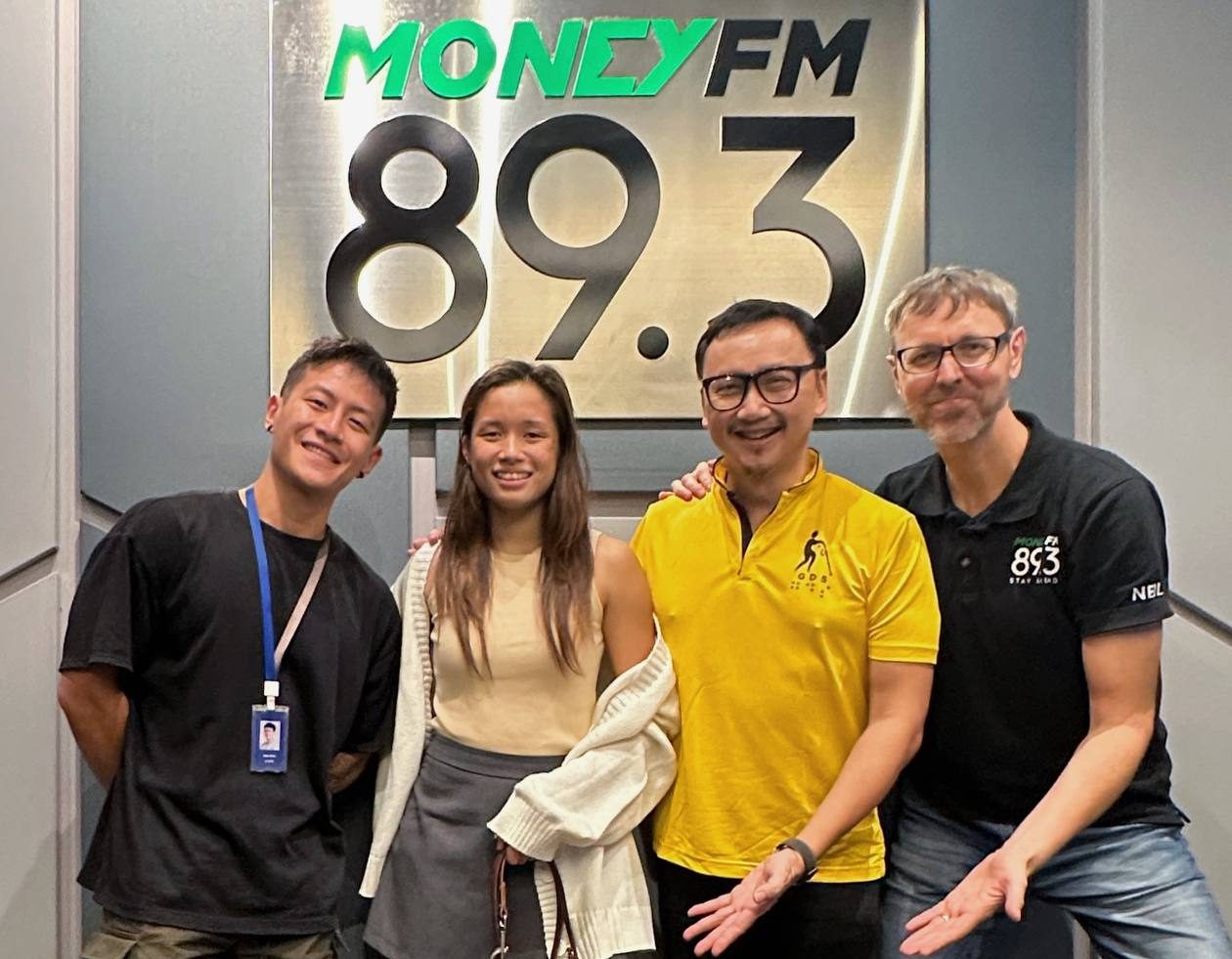 Sophie, her guide dog Orinda, Dr Wong, and hosts from 89.3 Money FM, Neil Humphreys and Dan Koh, posing together in a group photo.