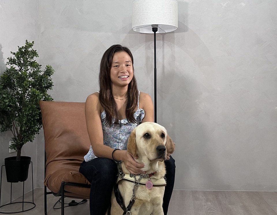 A guide dog user hugging her yellow Labrador guide dog.
