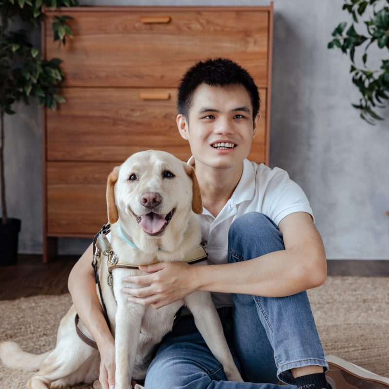Guide dog user Hong Sen posing for a photo with his guide dog Clare. 