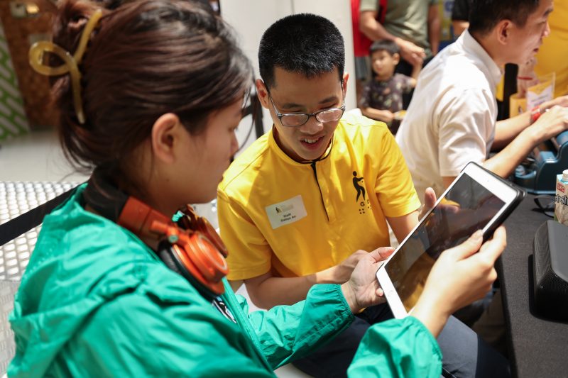 GDS IT trainer is showing a participant how to use the assistive features on an iPad.