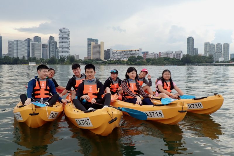 GDS clients and volunteers sitting in kayaks, posing for a group photo.