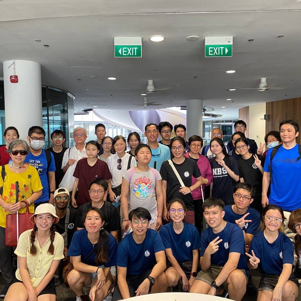 A group photo of GDS clients and student volunteers from NTU, all smiling.