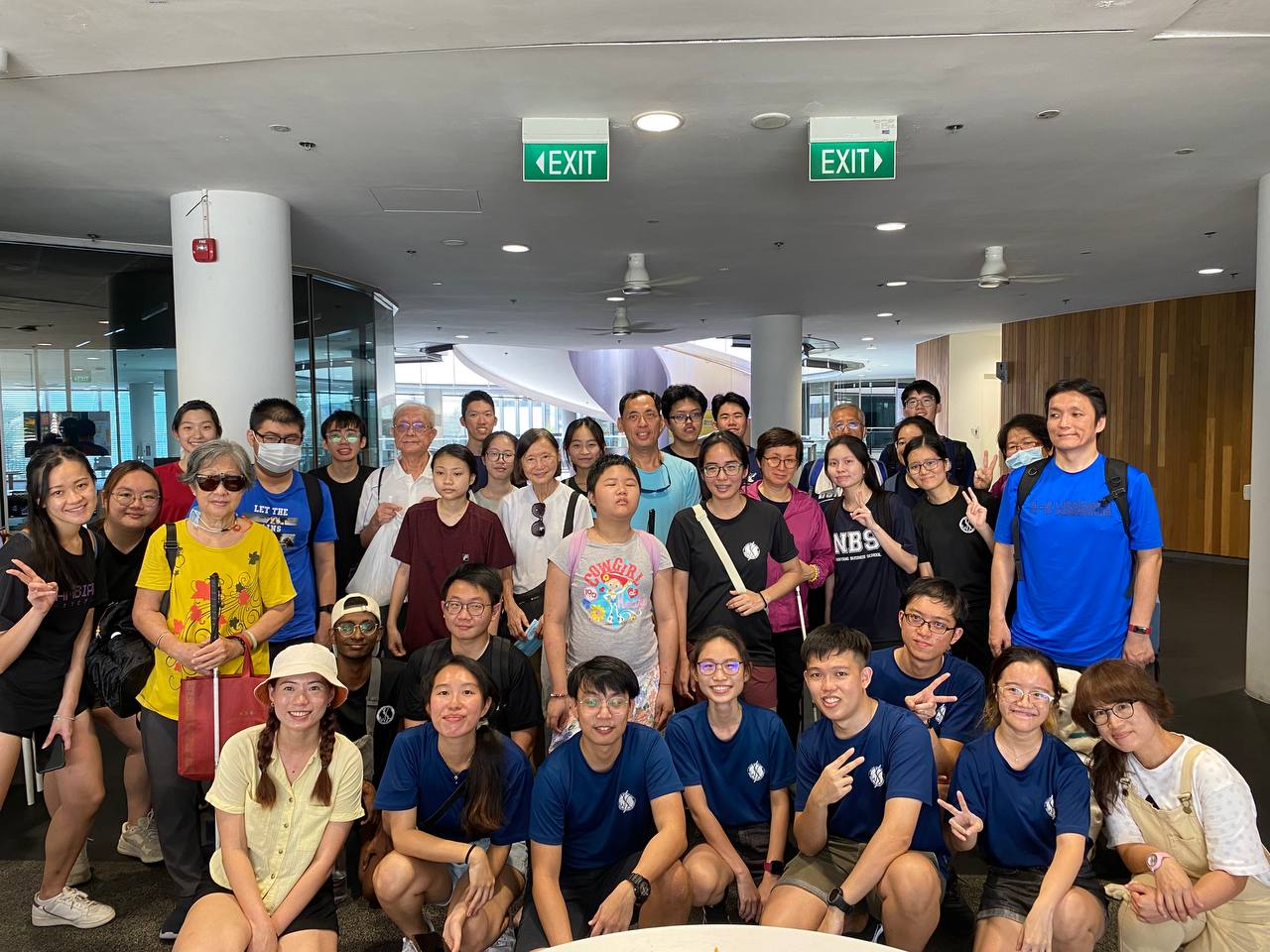 A group photo of GDS clients and student volunteers from NTU, all smiling.