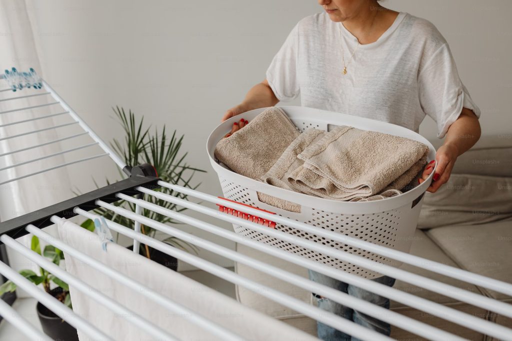 A woman holding a laundry basket filled with clothes.