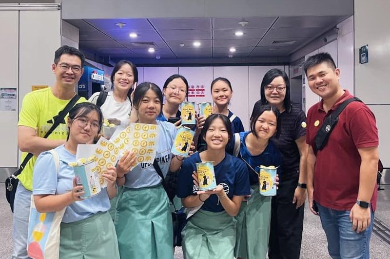 A group of student volunteers and their teachers smiling while holding a Flag Day 2024 donation tin.