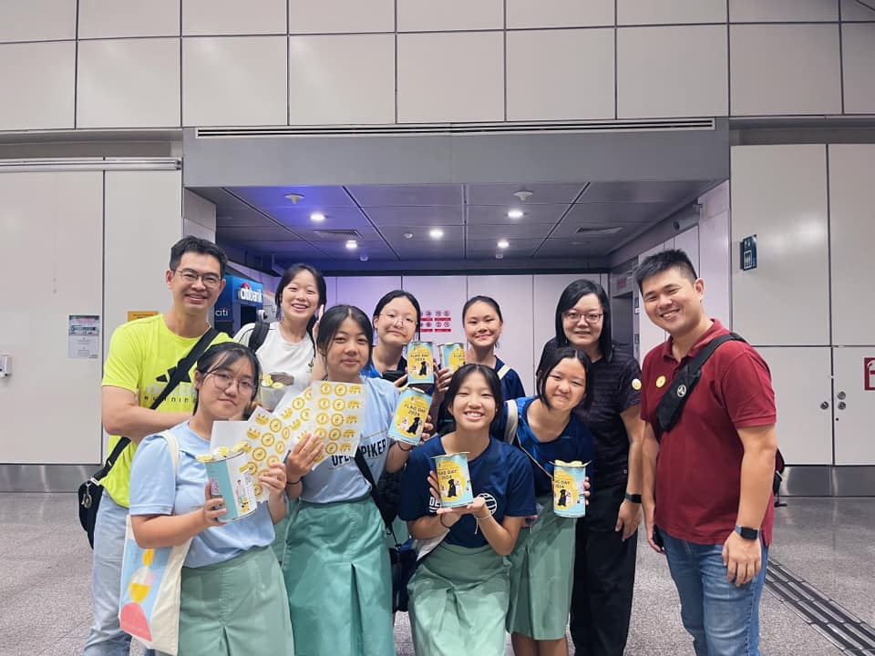 A group of student volunteers and their teachers smiling while holding a Flag Day 2024 donation tin.